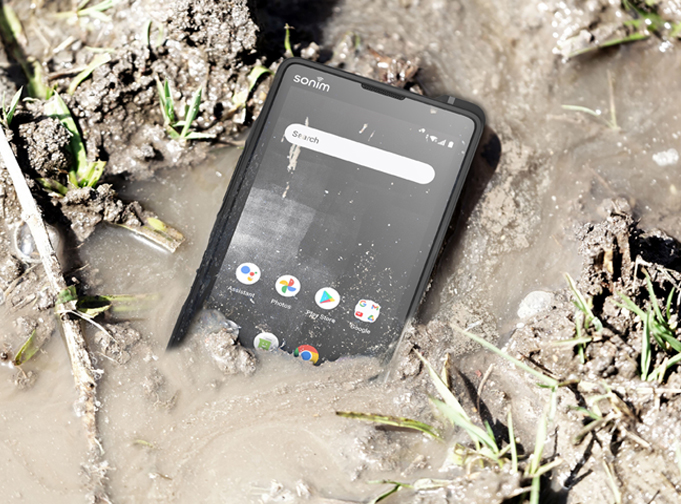 Photo of the Sonim XP10 5G smartphone in a muddy puddle