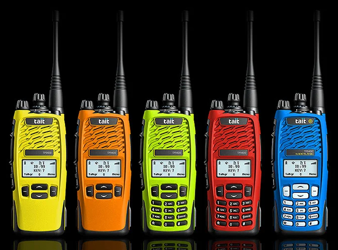 Tait P25 TP9400 with configurations shown against a black background. Colours include hi-vis yellow, orange, red, hi-vis green and IS blue colourways.