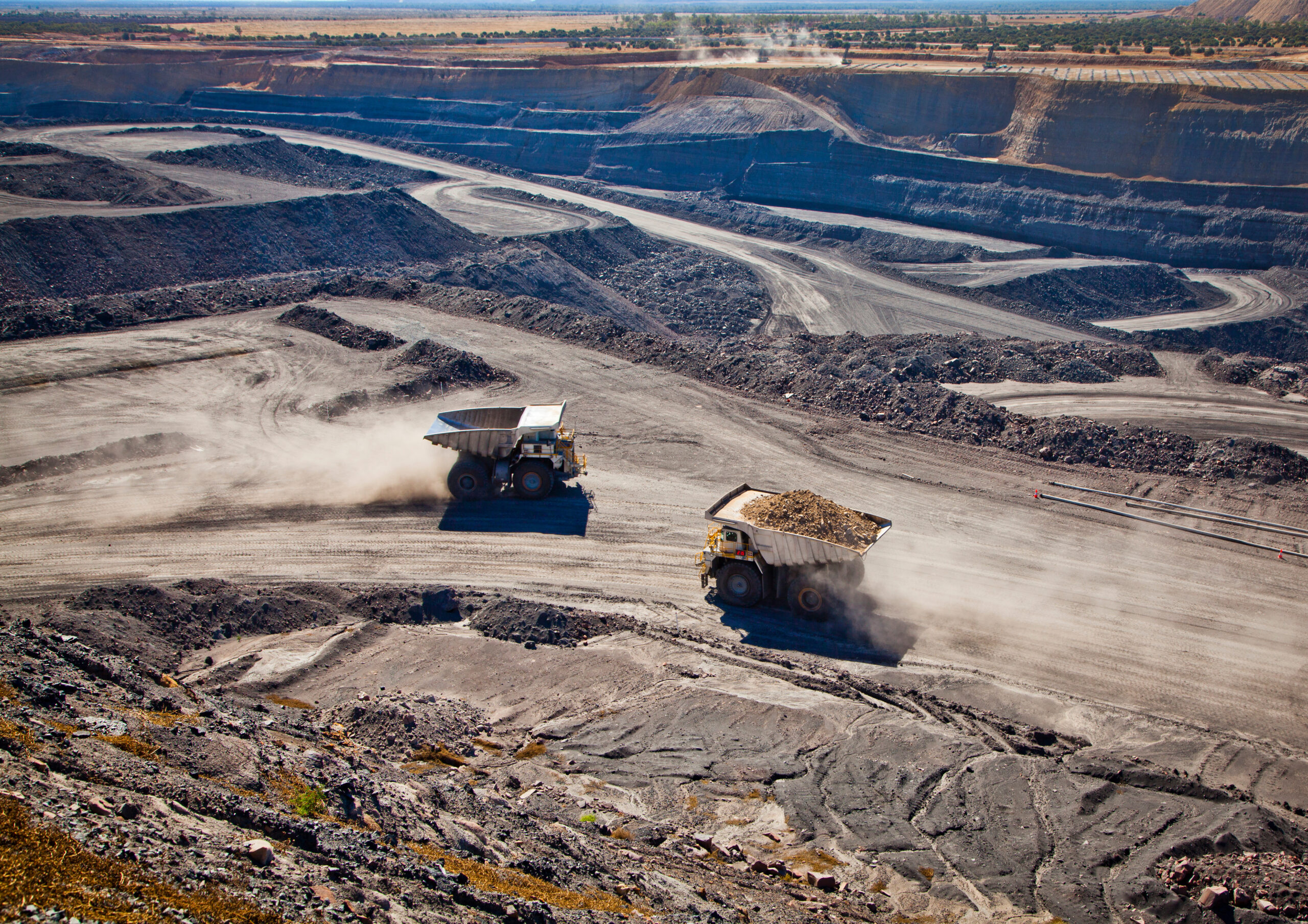 Two trucks carrying coal at a mine site at Blackwater in Australia.